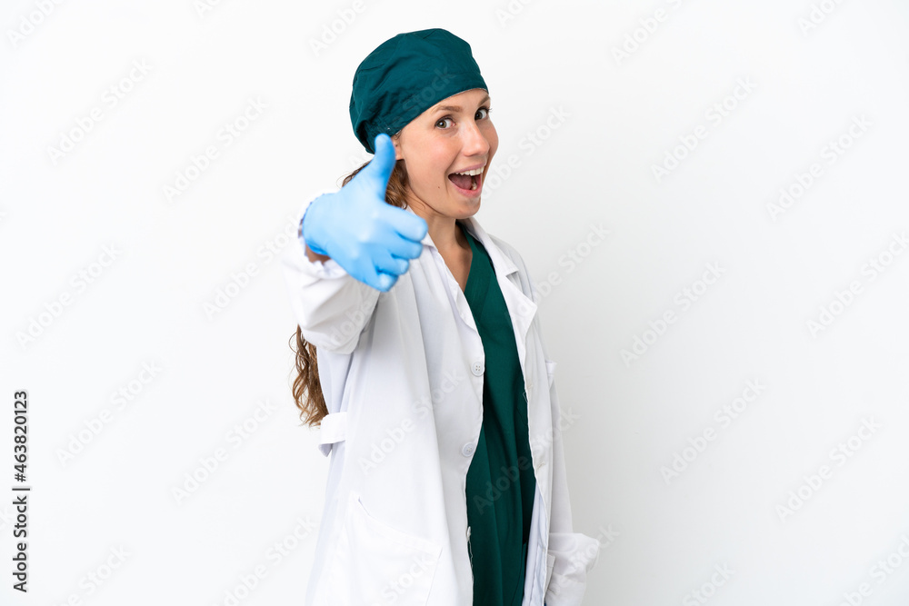 Surgeon caucasian woman in green uniform isolated on white background with thumbs up because something good has happened Surgeon caucasian woman in green uniform isolated on white background with thumbs up because something good has happened