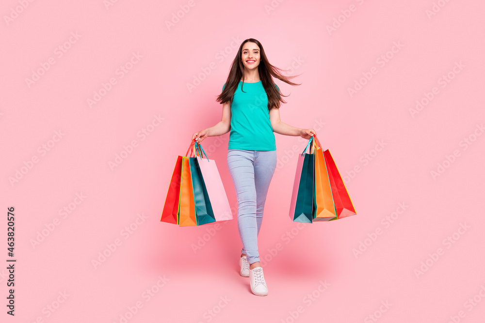 Full body photo of young woman happy positive smile go walk black friday shopaholic isolated over pastel color background Full body photo of young woman happy positive smile go walk black friday shopaholic isolated over pastel color background