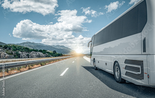 White passenger bus on the highway against the backdrop of a beautiful landscape. photo
