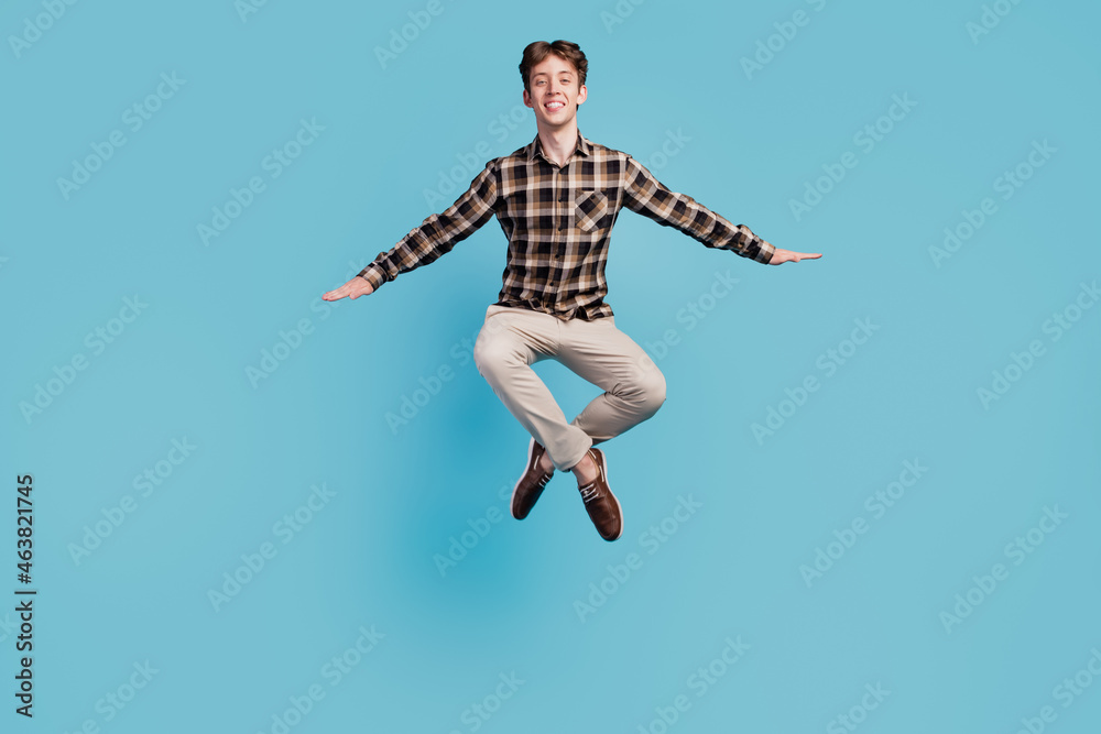Full body photo of young cheerful excited guy have fun jump active isolated over blue color background