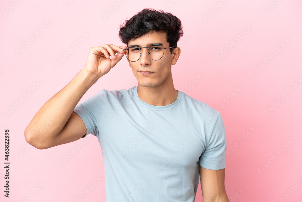 Young Argentinian man isolated on pink background With glasses and frustrated expression Young Argentinian man isolated on pink background With glasses and frustrated expression