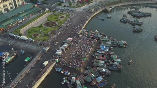 Harbor town with crowded port and traditional fishing boats moored to sea pier near fish market attracts tourists aerial view Ha Long Bay Vietnam