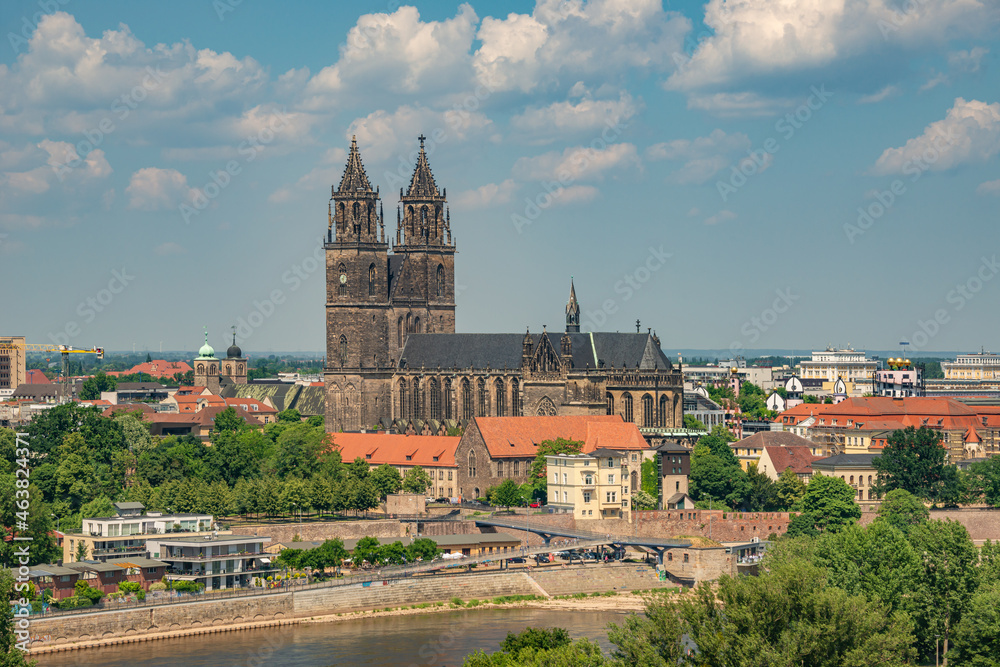 Aerial bird view over Magdeburg historical downtown, Elbe river, city park and the ancient medieval cathedral in Spring colors at blue cloudy sky and sunny day, Magdeburg, Germany.