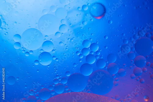 Water in oil in abstract style on blue background. blue liquid splash. Golden yellow bubble oil abstract background.