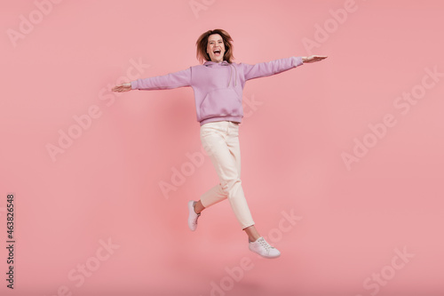 Full body photo of mature woman carefree happy positive smile jump wings fly isolated pink color background