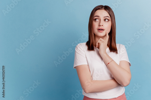 Photo of young lovely girl finger touch chin minded idea think curious look empty space isolated over teal color background
