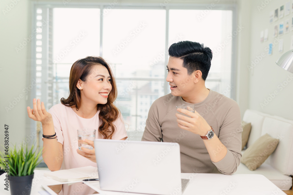 cheerful young male and female laughing while making plans for family budget communicating cheerful young male and female laughing while making plans for family budget communicating