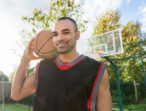 Smiling Basketball Player Holding a Ball