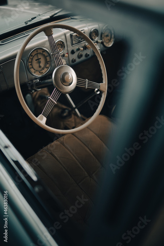 Oldtimer car dashboard. Retro car interior. Old steering wheel detail.