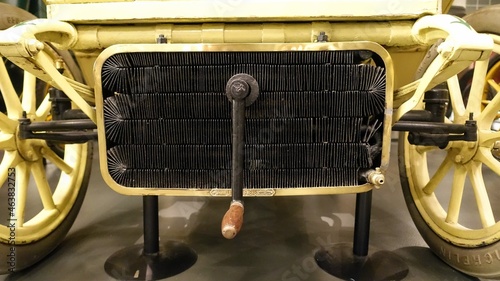 a view of a radiator and a crank of an antique car  photo