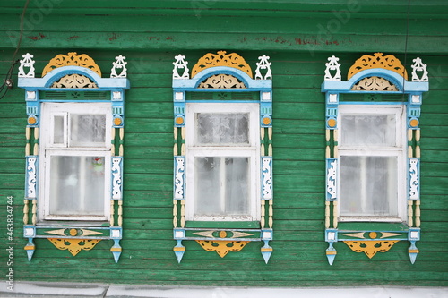 Ornamental windows with carved frames on vintage wooden rural house in Nerekhta town, Kostroma region, Russia. Building facade. Russian traditional national folk style in architecture. Russan landmark photo