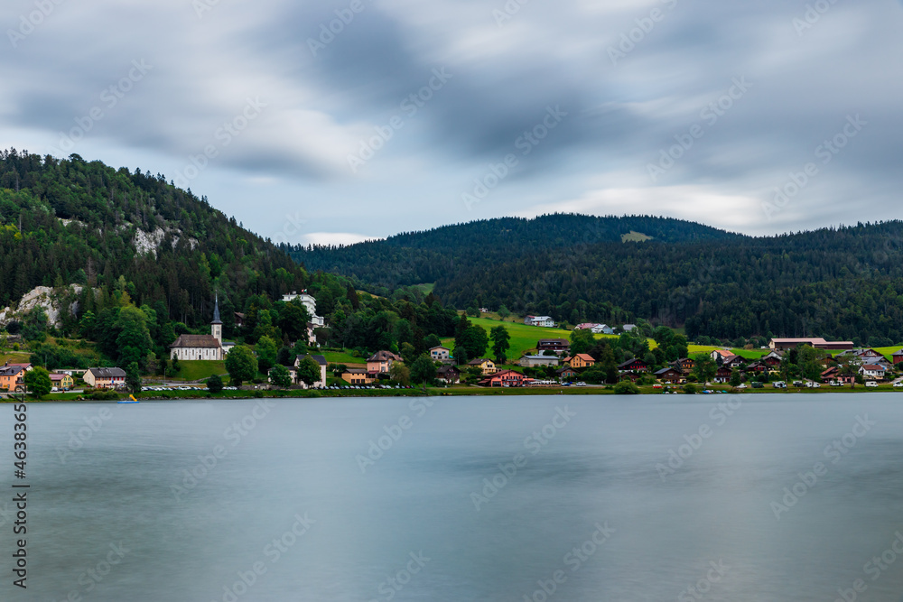 Long exposure bz the lake, Swiss alps and cathedral in Le Pond, Switzerland