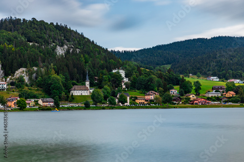 Fototapeta Naklejka Na Ścianę i Meble -  Long exposure bz the lake, Swiss alps and cathedral in Le Pond, Switzerland