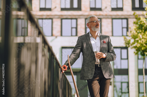 A mature man standing in the yard near the offcie building photo