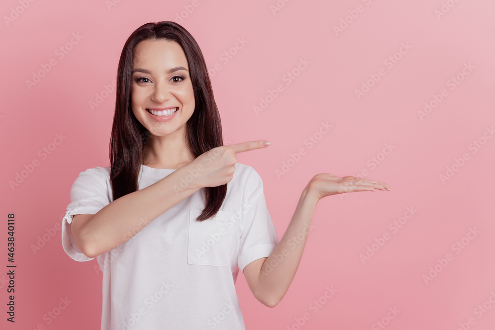 Photo of young girl indicate finger product promotion advertise discount isolated over pink color background Photo of young girl indicate finger product promotion advertise discount isolated over pink color background