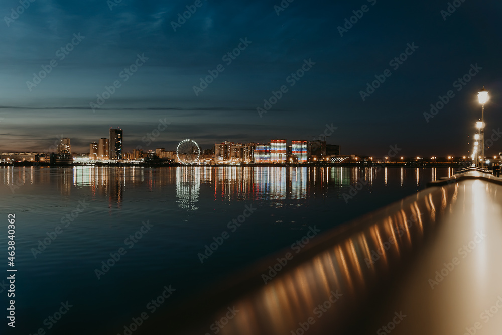 City night lights. Kazan embankment. New residential complexes. Reflection on the surface of the water. Long-term exposure.