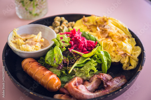 Big breakfast with pork bacon, sausage, mushroom, pickles, scramble eggs and salad.