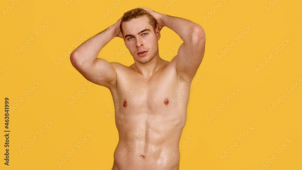 Male fashion model. Young handsome muscular guy looking at camera, demonstrating perfect body, slow motion Male fashion model. Young handsome muscular guy looking at camera, demonstrating perfect body, slow motion