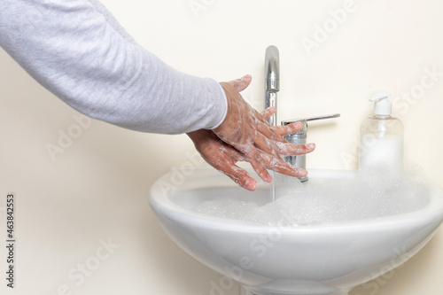 Close up photo of an ocd patient while washing hands for long periot of time. Concept of hygiene and ocd. photo