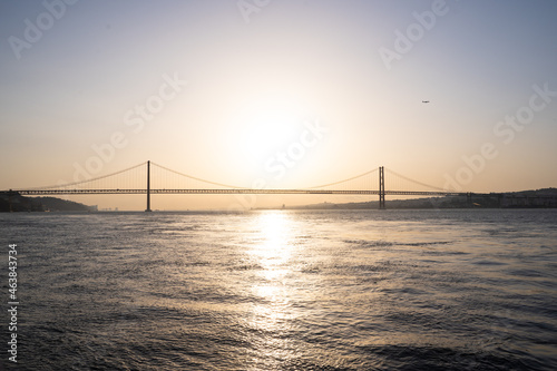 Sunset in the middle of a river with a majestic bridge