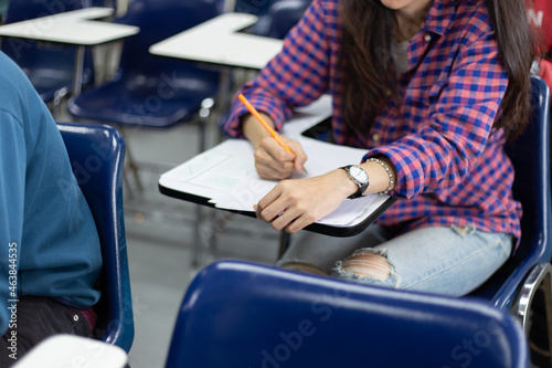 high school,university student study.hands holding pencil writing paper answer sheet.sitting lecture chair taking final exam attending in examination classroom.concept scholarship for education abroad