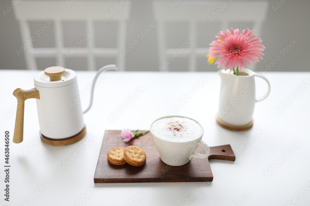 cappuccino coffee and sandwich cookie on white wooden table cappuccino coffee and sandwich cookie on white wooden table