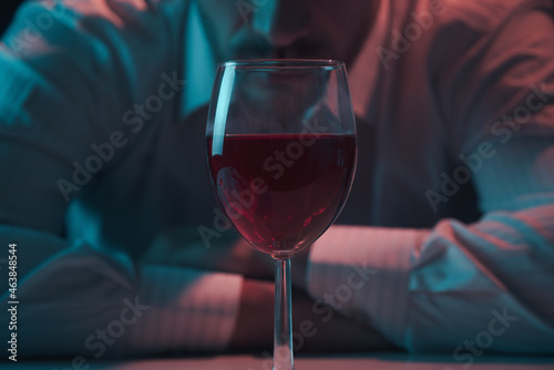 Glass of wine close up. Man leaning over a glass of alcohol. photo