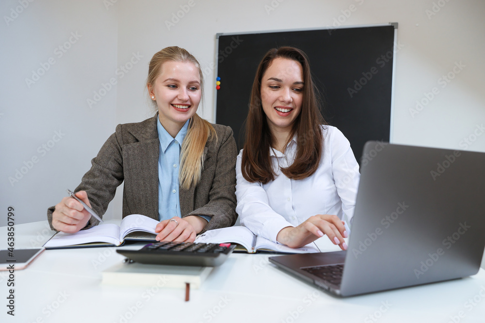 Two young women working on a laptop Two young women working on a laptop