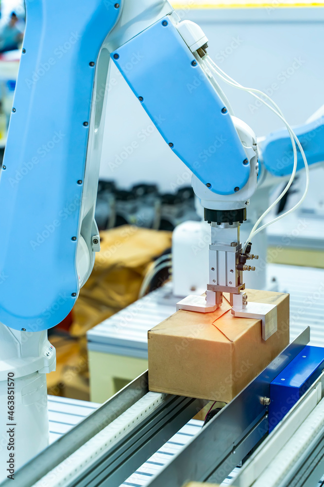 Articulated robotic arm at packaging line in industrial manufacture ...