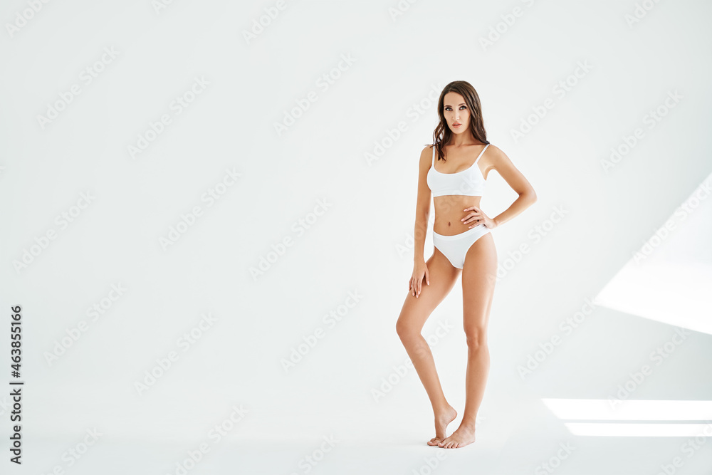 Sporty beautiful woman with slim body in white underwear. Healthy lifestyle, sport, bodycare concept. Copy space Sporty beautiful woman with slim body in white underwear. Healthy lifestyle, sport, bodycare concept. Copy space