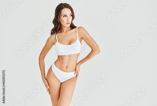 Young and sporty woman in underwear posing on white studio background  with copy space