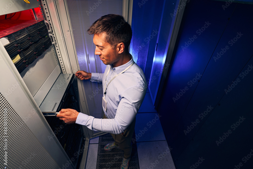 Expert male engineer replacing old hardware component Expert male engineer replacing old hardware component