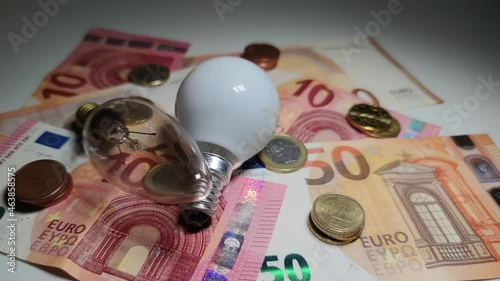 Luz variable sobre dinero y bombillas queriendo mostrar el precio de la electricidad photo
