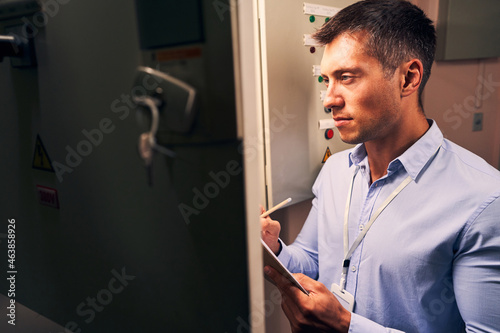 Male engineer concentrated on monitoring operation of equipment