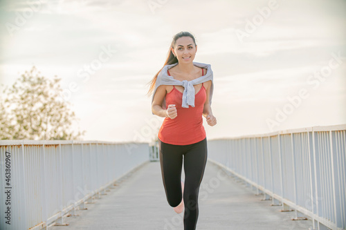 Fitness woman running on city road