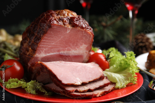 Plate with delicious ham, lettuce and tomatoes on black wooden table, closeup