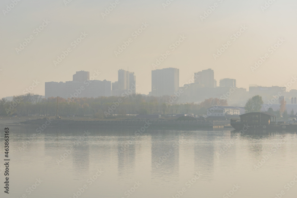 Fototapeta premium View of the city from the river. Smog air pollution 