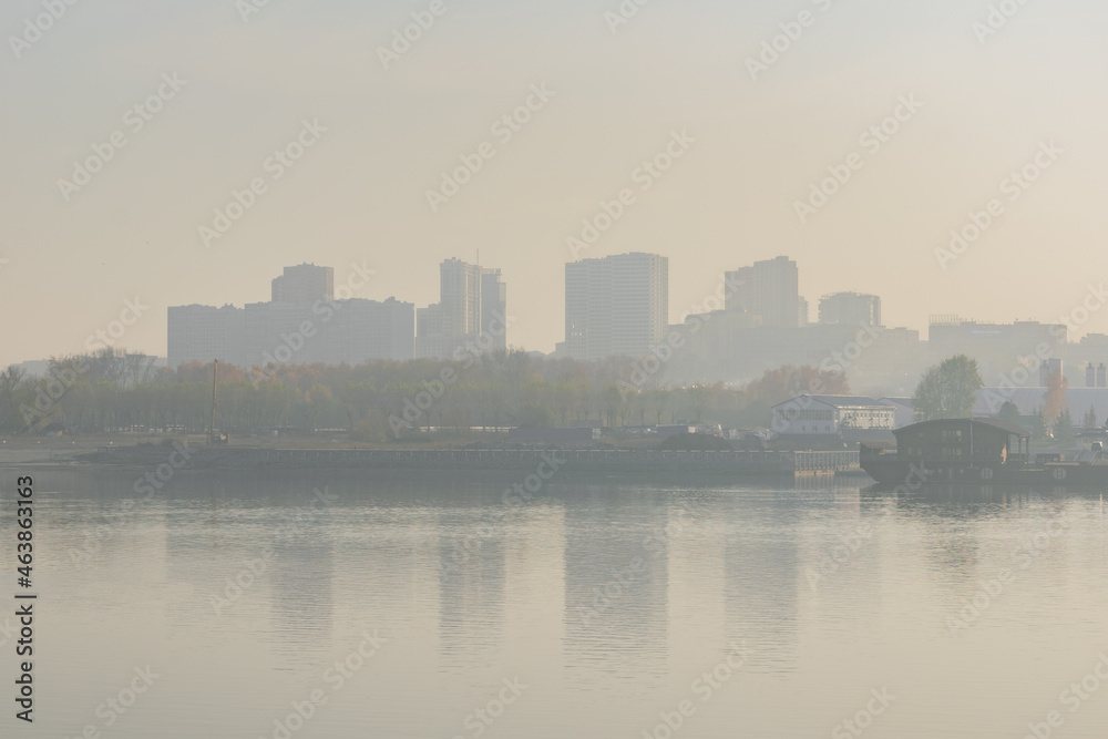 View of the city from the river. Smog air pollution 