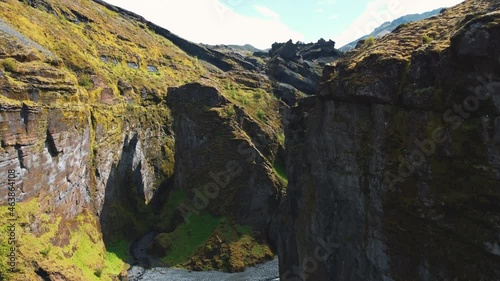 The aerial reveal of mountain peaks above cliffs of a rocky ravine photo