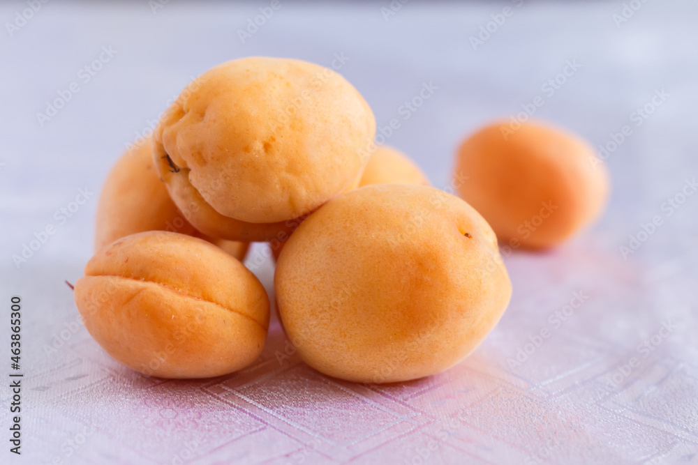 pyramid of apricots on a white tablecloth pyramid of apricots on a white tablecloth
