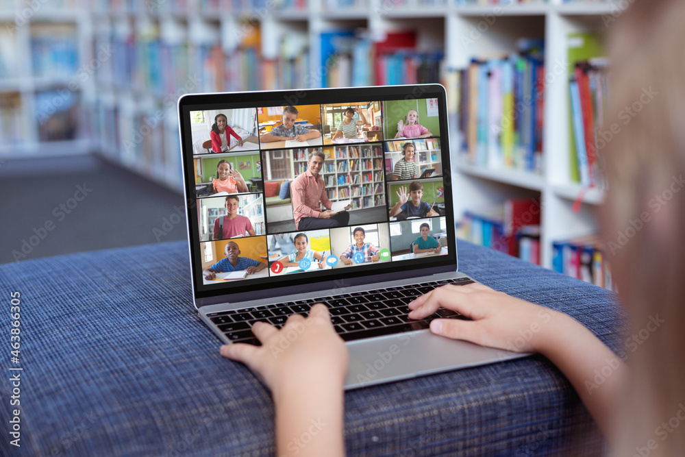 Caucasian girl using laptop for video call, with smiling diverse elementary school pupils on screen Caucasian girl using laptop for video call, with smiling diverse elementary school pupils on screen