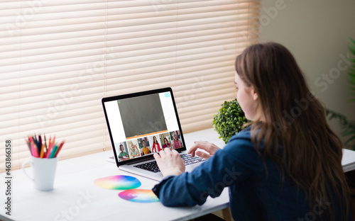 Caucasian girl using laptop for video call, with smiling diverse high school pupils on screen © vectorfusionart