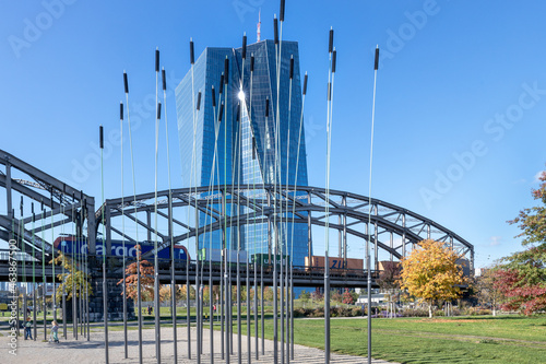 Europäische Zentralbank mit der Deutschherrnbrücke und herbstlichen Bäumen im Hafenpark in Frankfurt am Main photo