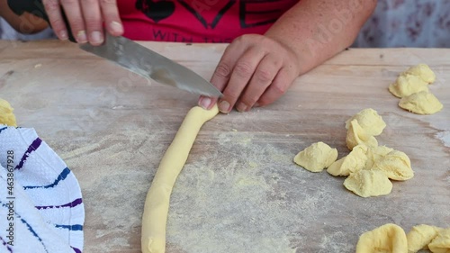 Bari, Puglia, Italy. August 2021. Close-up footage of a senior lady's skilled hands as she prepares orecchiette: local pasta specialties. With quick gestures the raw pasta becomes orecchietta. photo