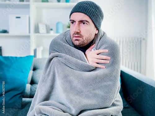 Fototapeta Man suffering cold at home and problem with house heating