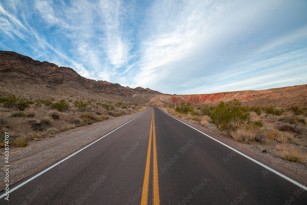Driving down an empty road through the desert mountains Driving down an empty road through the desert mountains