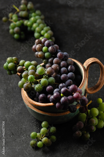 grape bunches in ceramic cups on gray background