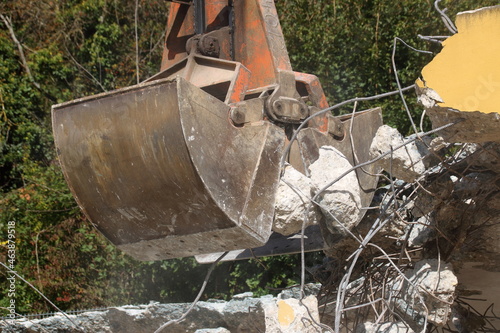 Aufladen von Bauschutt mit einem Bagger in staubiger Umgebung photo