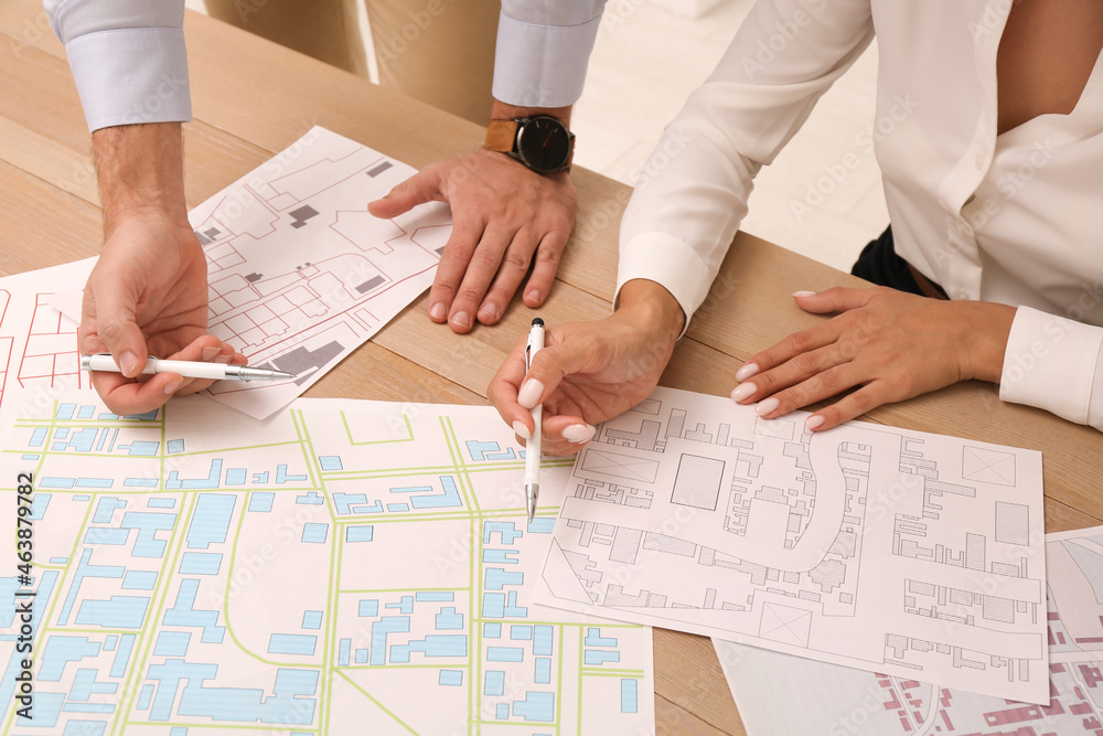 Professional cartographers working with cadastral map at table, closeup Professional cartographers working with cadastral map at table, closeup