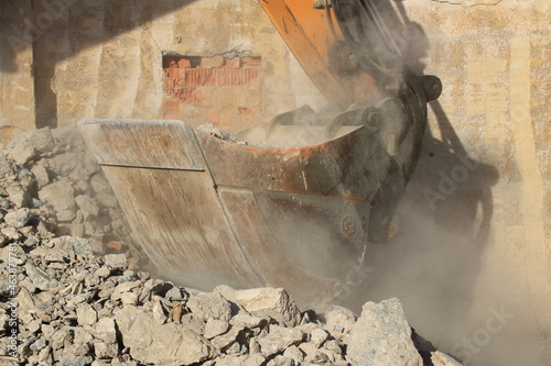 Aufladen von Bauschutt mit einem Bagger in staubiger Umgebung photo